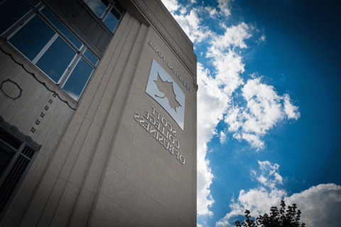 PHOTO OF MULTI STORY BUILDING WITH LARGE INDIANA STATE LEAF LOGO AND TEXT “FEDERAL HALL” AND “SCOTT COLLEGE OF BUSINESS” WITH BLUE SKY IN THE BACKGROUND